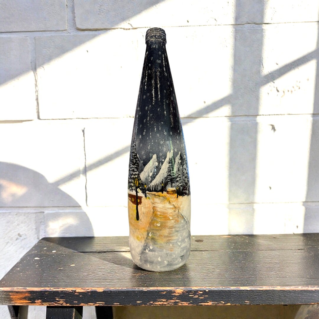Hand-painted winter night bottle with snowy trees, mountains and glowing lanterns, bottle painting workshop at Colourful Wine Tallawong